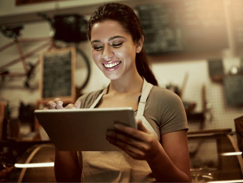 Young woman using a digital tablet while working in a coffee shop