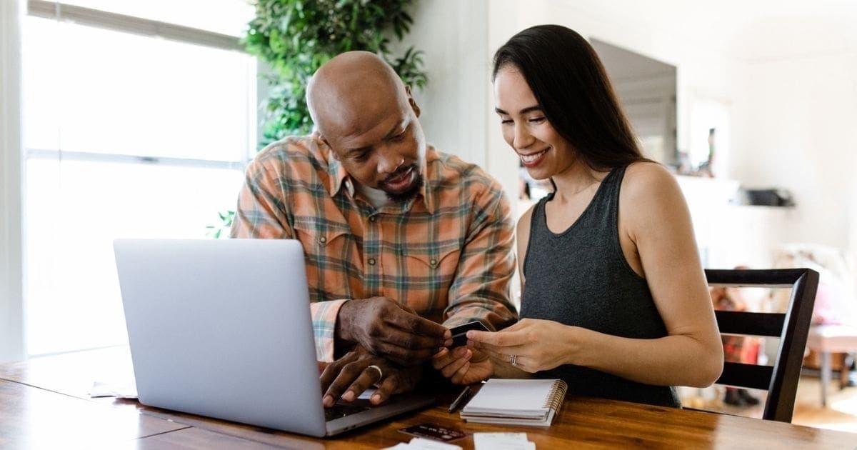 A man and a woman looking at a computer