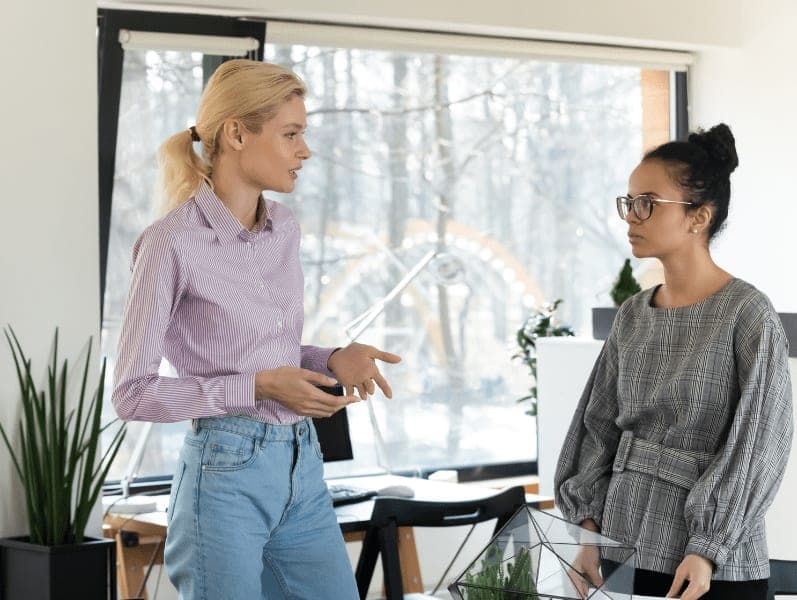 Young blonde businesswoman talking with collegue at the office
