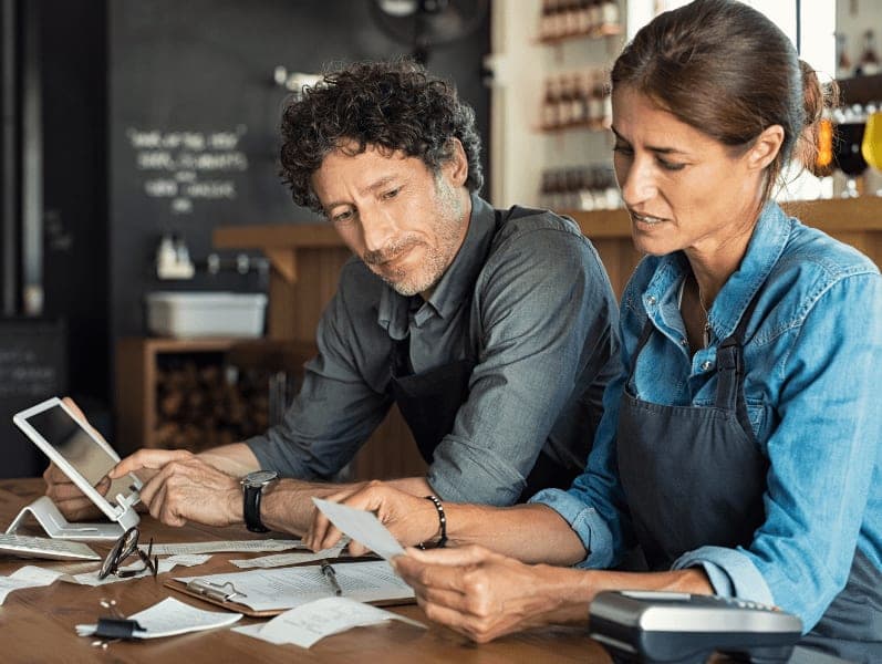 Business owners sitting together looking at expenses and bills