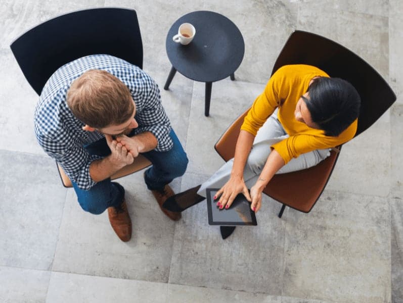 Overhead view of two entrepreneurs meeting in the office
