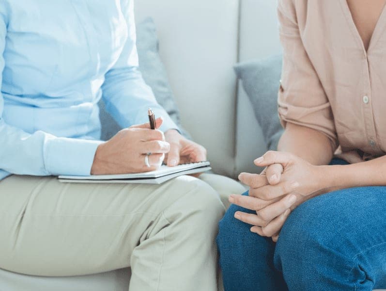 therapist writing down notes with patient