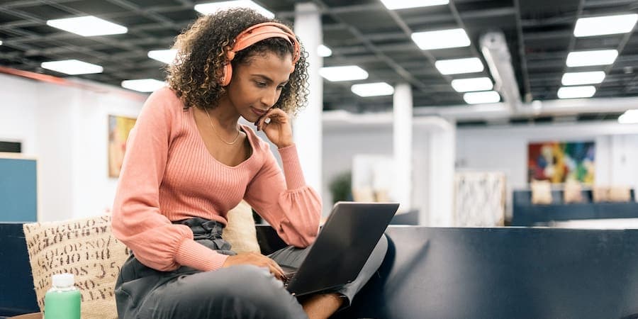 woman with headphones working on laptop