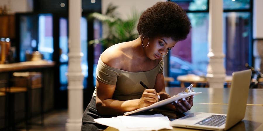 woman writing on clipboard