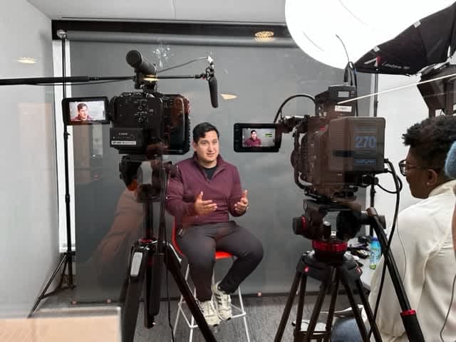 A person sits in front of a camera.