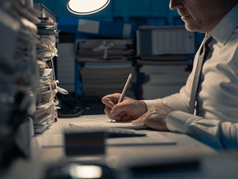 Male accountant sitting at his desk working at night.