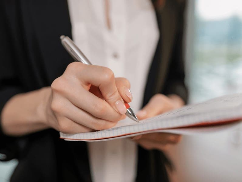 Female taking notes based on her leadership profile