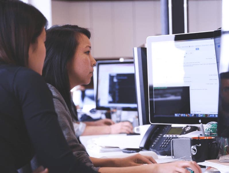 Female sitting in front of computer reviewing a timesheet