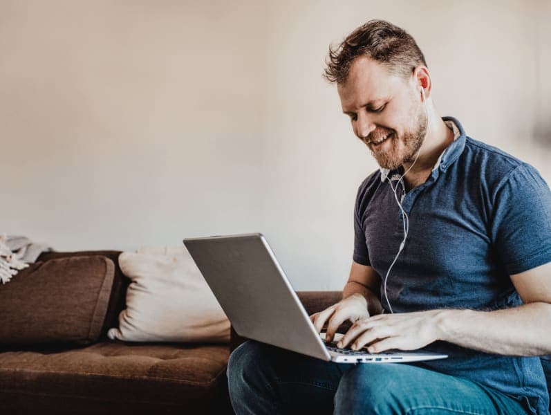Male working remote from his laptop from the living area