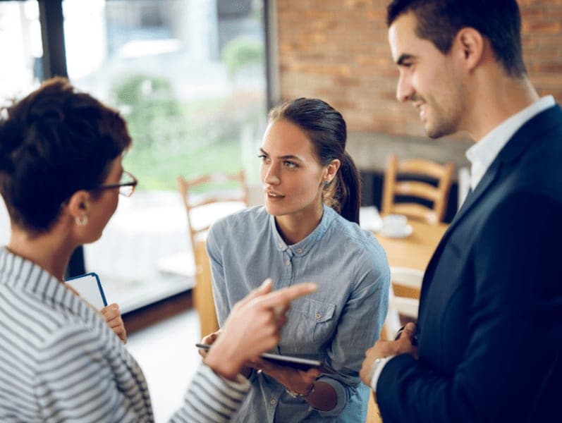 Female colleague speaking with colleagues about tools to support firms efficiency