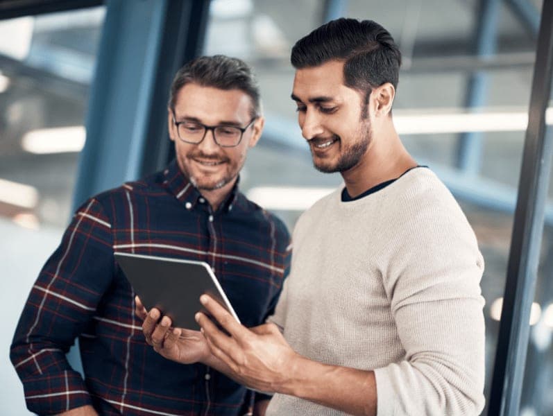 Two male colleagues collocating with an table tool
