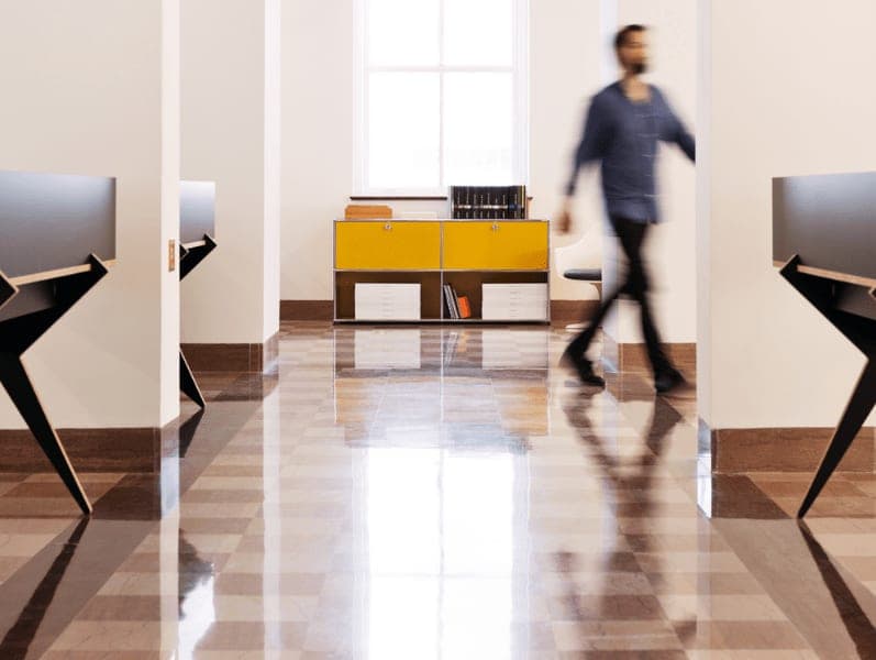 Man walking across hallow with a view down a hallway