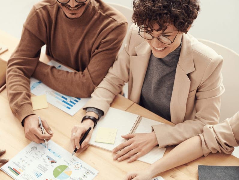 Male and female colleague sitting beside each other reviewing the go to market strategy
