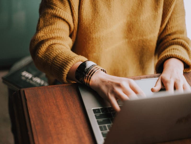 Female sitting in front of lap top with only torso view