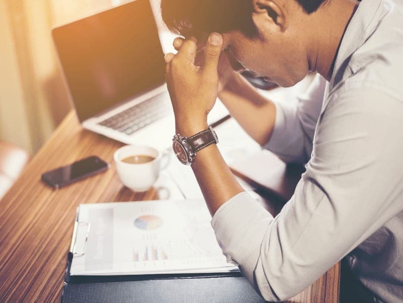 Male small business owner stressed about his company's financial situation.