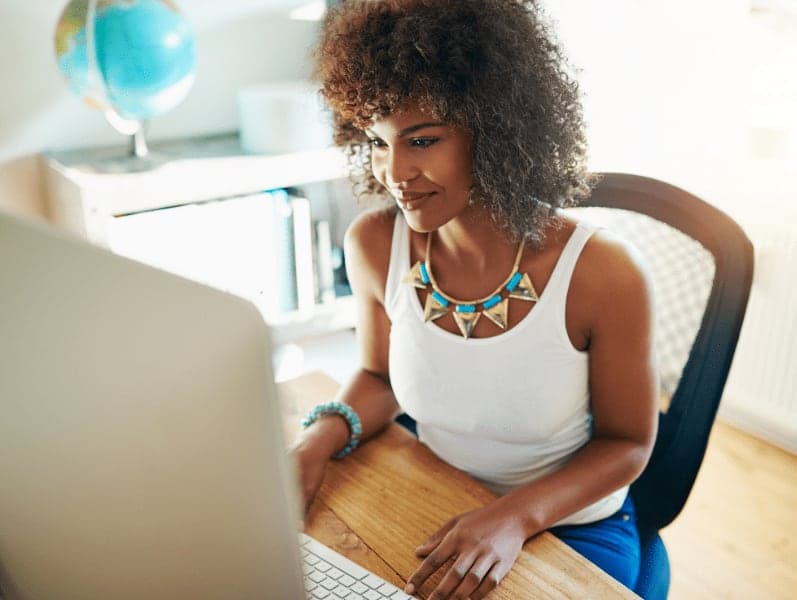 Woman sitting in front of the desk in front of desktop screen
