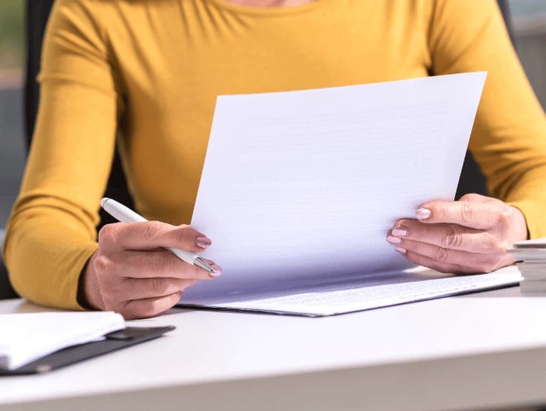 Woman sitting at desk with paper work to review