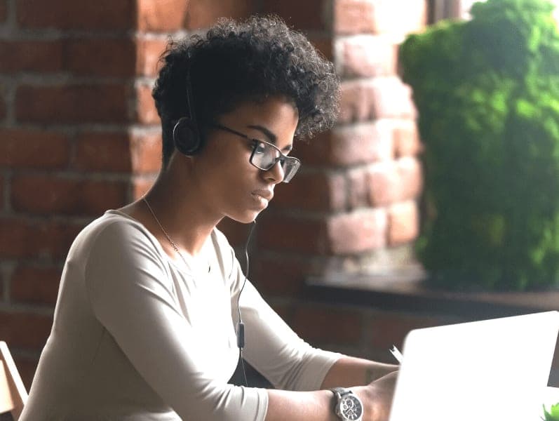 Young women sitting in front of computer listening to online learning