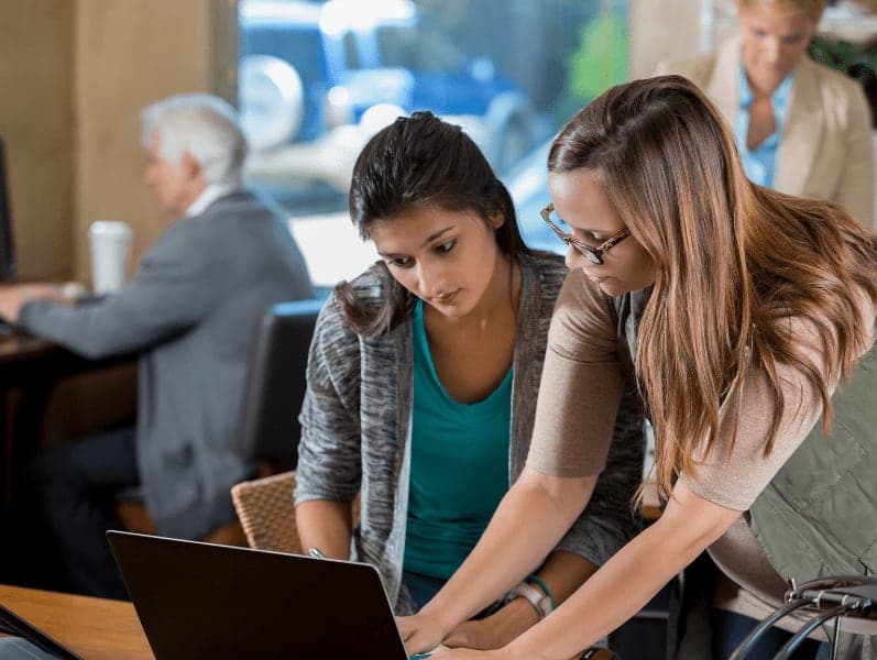Two female colleagues beside each other while one is supporting the other